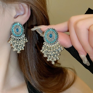 Detail of vintage bohemian earrings with blue gems and antique silver bead tassels