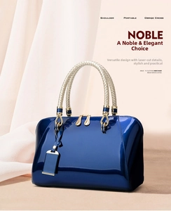 Close-up of dark blue patent leather handbag with woven handles and gold hardware