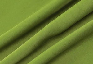 Close-up of green textured fabric detail showing soft wavy pleats and woven material