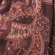 Macro view of brown fabric featuring intricate red and orange paisley print texture