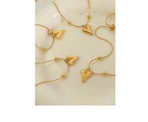 Close-up of heart charm bracelets on a white ceramic plate with a polished gold finish