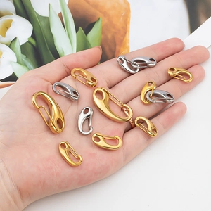Set of gold and silver stainless steel lobster clasps held by hand for scale display