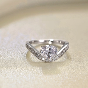 Macro shot of an oval-cut gemstone ring with V-shaped pavé diamond band
