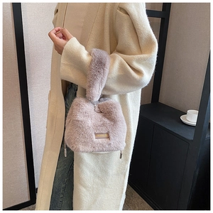 Macro detail of plush faux fur bucket bag in pink-purple with elegant metal handle