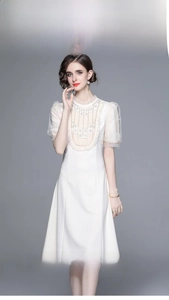 Détail de la robe blanche avec dentelle florale complexe et broderie de perles élégante