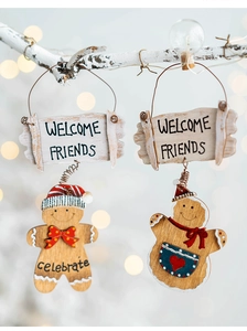 Christmas wooden gingerbread man welcome sign hanging on a white branch with soft lights