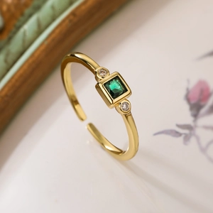 Adjustable gold ring featuring a green square gemstone and sparkling side diamonds