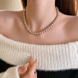 French vintage pearl necklace featuring champagne gold beads on an elegant model