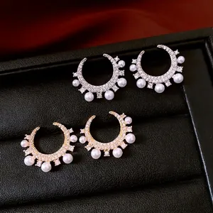 Elegant C-shaped earrings with gold and silver plating, featuring zircons and white pearls