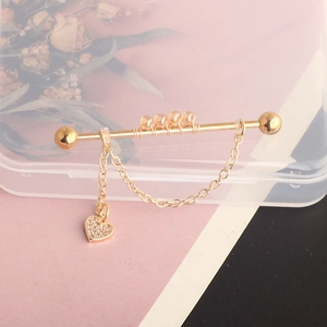 Detail of gold chain barbell earring with heart pendant and sparkling rhinestones