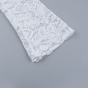 Gros plan détaillé sur la texture de dentelle florale blanche et la broderie de manche
