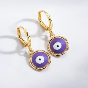 Golden earrings with purple devil eye pendants featuring white and black enamel detail