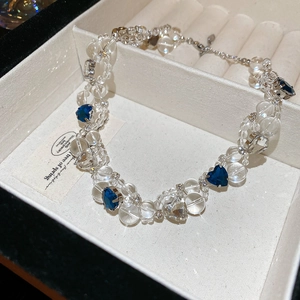 Detailed macro view of heart-shaped blue crystals and clear beads on the necklace