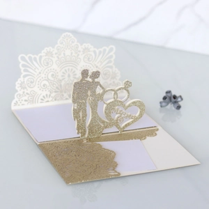 Macro detail of laser-cut 3D wedding card with gold glitter Mr & Mrs heart silhouette
