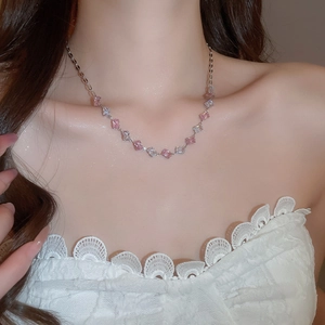 Close-up of pink and white cubic zirconia square pendant necklace on woman's neck