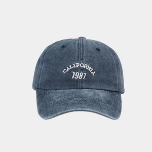 Detail of CALIFORNIA 1987 embroidery on navy blue washed denim baseball cap