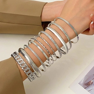 Detail of silver alloy bracelet set featuring smooth finish and textured link designs