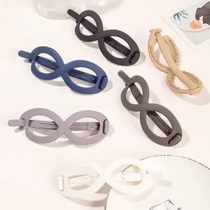 Top view of large infinity hair clips in matte navy, grey, camel, and purple colors
