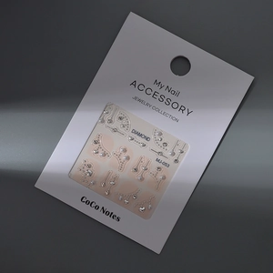 Detailed view of MJ-053 nail art charms with crystal rhinestones and pearls on display card