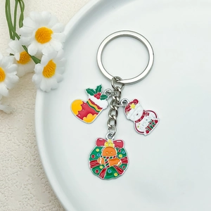 Christmas themed metal keychain featuring Santa sock, snowman and wreath pendants