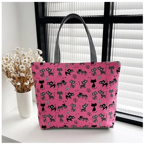 Detail of floral pink canvas tote bag with cat prints on a sunlit white windowsill