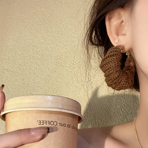 Chic dark brown knitted round hoop earrings for women shown in a lifestyle profile view