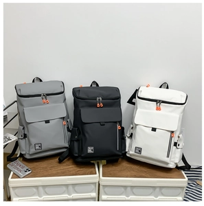Three large capacity travel backpacks in grey, black and white with orange zipper details