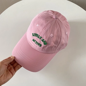 Detail of pink nylon baseball cap with green Lively and Active embroidery on the front