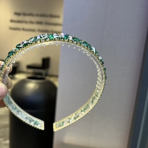Detail of baroque headband with green crystals and inner comb for secure grip
