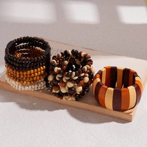 Detail of stacked wooden bead bracelets in earthy tones on an open book under natural light