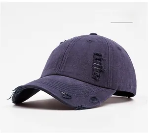 Détail du tissu denim vieilli et usé sur une casquette de baseball bleu marine