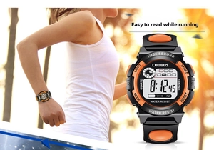 Close-up of children's digital sports watch with orange buttons and water resist dial