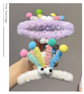 Detail view of purple and white fuzzy monster claw clips with spring hair grip design