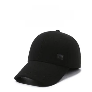 Detail of black wool baseball cap with ear flaps and square leather patch for winter