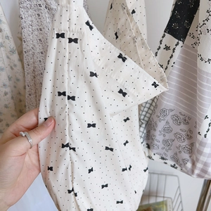 Gros plan sur le tissu en coton floral doux et le nœud à pois des sacs fourre-tout