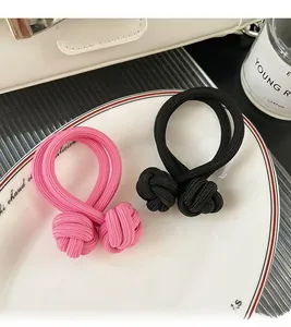 Détail d'élastiques à cheveux double brin roses et noirs avec nœuds sur une assiette