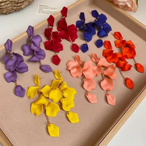 Elegant matte floral tassel earrings in six vibrant colors on a soft velvet display