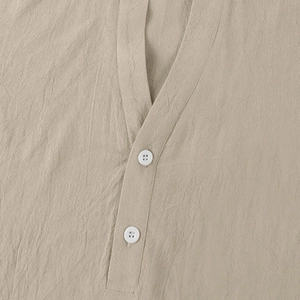 Detail view of khaki linen shirt featuring a grandad collar and white buttons