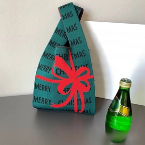 Détail du sac à main tricoté vert avec nœud rouge et motif de texte Merry Christmas