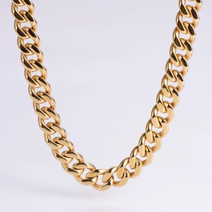 Close-up of a high-polished golden stainless steel Cuban link chain with detailed flat links