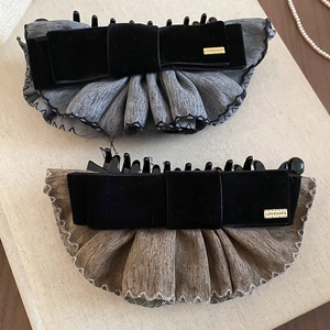 Détails de barrettes à nœud en velours avec volants en satin et étiquette dorée