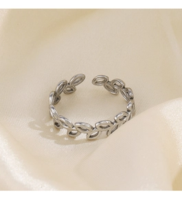 Macro detail of adjustable stainless steel ring with vintage olive leaf texture on satin