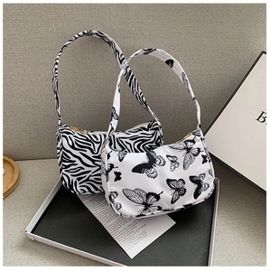 Detail view of zebra and butterfly print canvas baguette bags with zipper closure