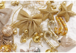 Close-up of golden and silver Christmas star ornaments with bows and glitter finish