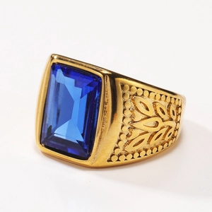 Close-up of golden stainless steel ring with rectangular blue gemstone and side engravings
