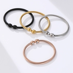 Detail of twisted cable therapy bracelets in black, gold, silver, and rose gold finish