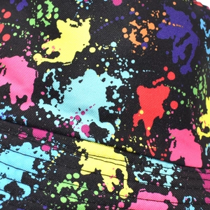 Detail of a tie-dye bucket hat featuring colorful graffiti patterns on black canvas fabric