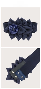 Macro detail of navy blue elastic waist belt with large chiffon flower and pearl center