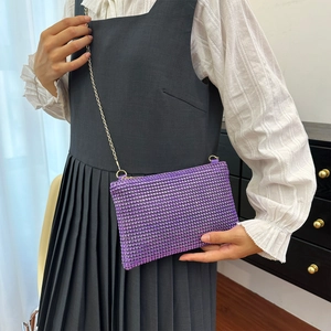 Detailed close-up of a purple rhinestone chain bag on a model to show texture and size