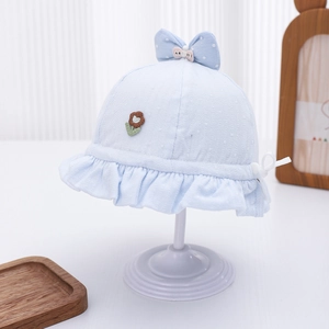 Detail of light blue baby sun hat with floral embroidery and polka dot bow accent